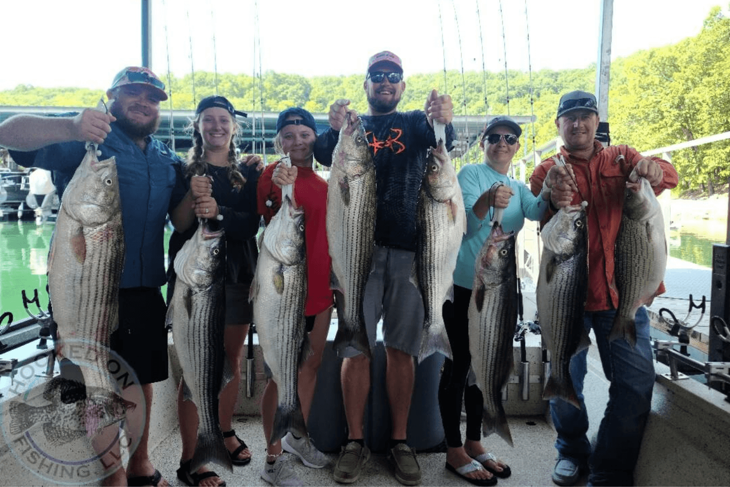 Group of people holding their catch of the day after a Hooked on Fishing trip on Beaver Lake